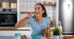 Woman enjoying a healthy breakfast cereal at home, representing mindful snacking habits for weight loss while using Semaglutide. healthy snacking tips for weight loss