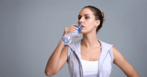 Woman drinking water from a bottle while tracking weight loss journey Hydration for Weight Loss: 6 Proven Benefits + Tips