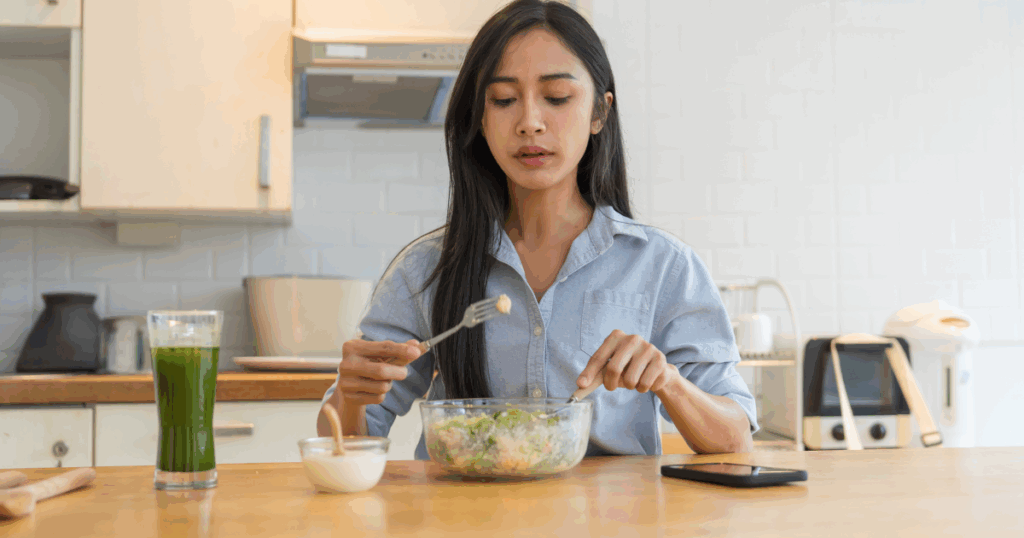 Woman eating a plant-based meal with green smoothie for healthy weight management